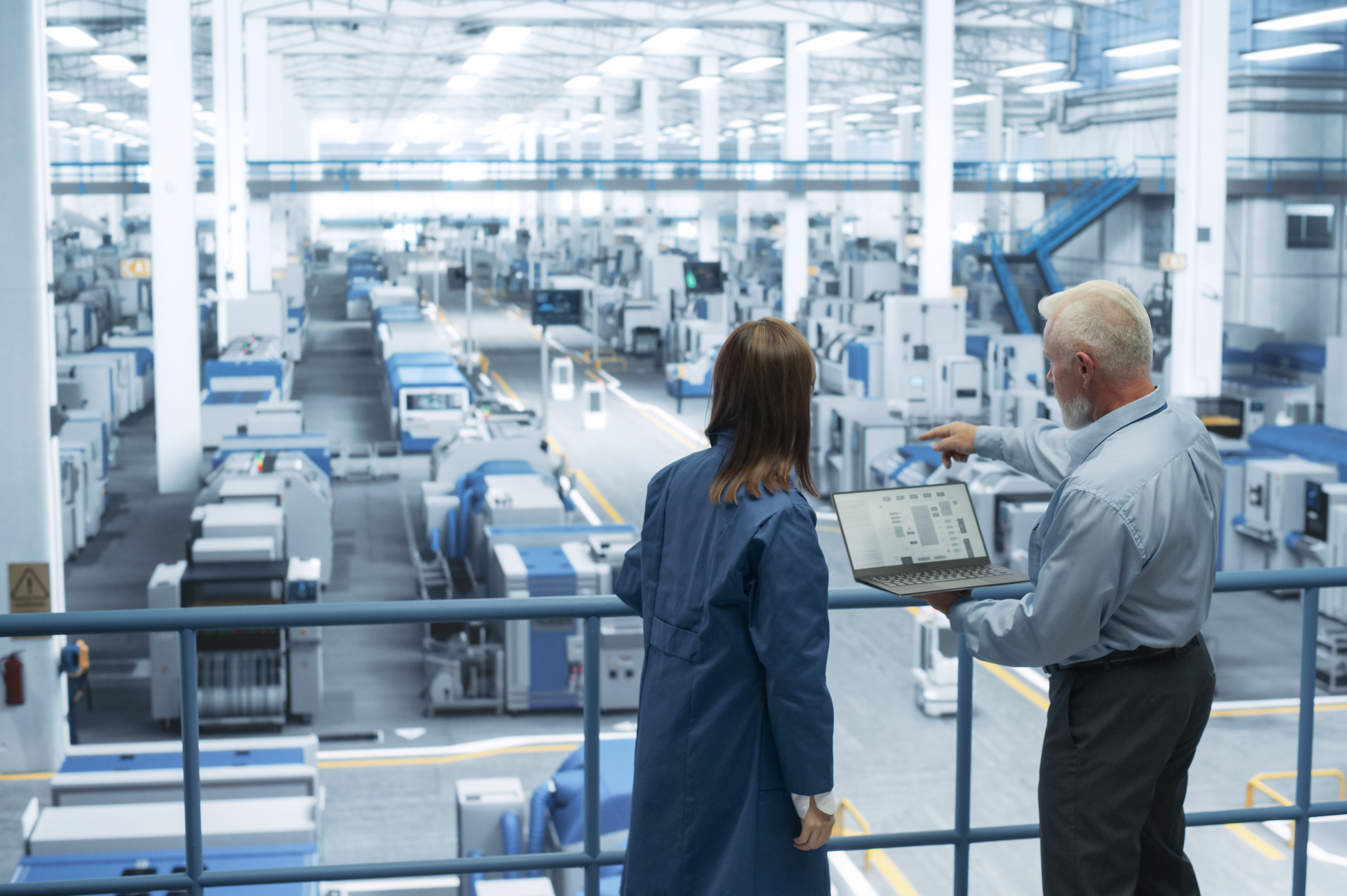 Berater und Kunde vor der Fertigungslinie im Gespräch